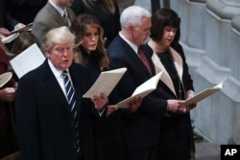 From left, President Donald Trump, first lady Melania Trump, Vice President Mike Pence and his wife Karen, sing together during a National Prayer Service at the National Cathedral, in Washington, Jan. 21, 2017.