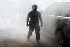 A Border Patrol agent walks through a cloud of tear gas on Tuesday, Oct. 14, 2025, in Chicago.
