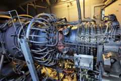 Gas turbine engine of feed gas compressor inside enclosure.