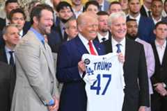 President Donald Trump holds up a jersey alongside pitcher Clayton Kershaw (L) and team owner Mark Walter (R) during an event honoring the 2024 World Series champions Los Angeles Dodgers in the East Room of the White House in Washington, DC, on April 7, 2025.