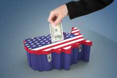 A photo representing money in politics, showing a hand stuffing money into a ballot box shaped like the U.S.