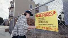 Deanna Del Bridge hangs a sign on a fence which expresses her love for her neighbors in San Francisco?s Marina District 