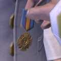 Terrence Hood holds Jacob Keyes' Colonial Cross, which was accepted by Miranda Keyes.