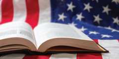 an open book laying on an American flag