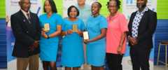 Minister of Health and Wellness Dr the Honourable Christopher Tufton (centre) joins the three top performers from the batch of 41 Community Health Aides (CHAs) who received Foot Care Assistant Level 1 Training under the Health Systems Strengthening Programme (HSSP), and other key representatives from the initiative. They are (from left) Owen Bernard, podiatrist from World Walk Foundation; Community Health Aides Shantel Harrage, Nardia Ferguson-Hopkins, and Cassandra Pusey-Brown; Professor Alafia Samuels, NCD Lead in the HSSP; and Orett Clarke, Programme Manager for the HSSP.