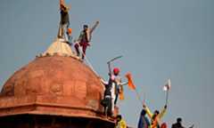 Protesters climb on a dome at the ramparts of the Red Fort as farmers continue to demonstrate against the Indian government's recent agricultural reforms in New Delhi on January 26. &mdash; AFP