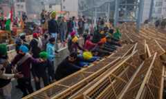 Protesting farmers break police barricades as they march to the capital during India's Republic Day celebrations in New Delhi on Jan 26. &mdash; AP