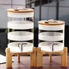 two glass containers sitting on top of wooden stands