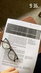 a person reading a paper with glasses on it
