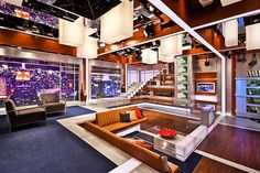 a living room filled with lots of furniture and large windows overlooking the city at night