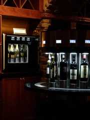 several bottles of wine sitting on top of a counter in a room with wood paneling