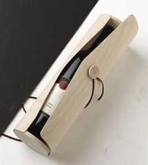 a bottle of wine in a wooden case on a white table with a black background