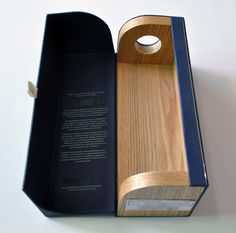 an open book with a wooden handle on the front and inside, sitting in a cardboard box