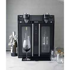 two wine glasses and bottles are sitting next to each other