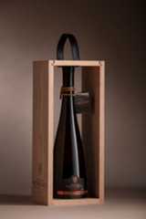 a bottle of wine in a wooden box with a ribbon around the neck and inside