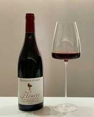 a wine glass next to a bottle of wine