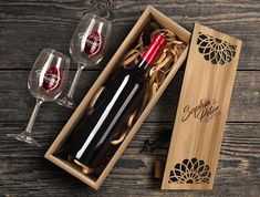 two wine glasses and a bottle in a wooden box