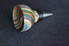 a close up of a wooden object on a black surface with a metal tip in the middle