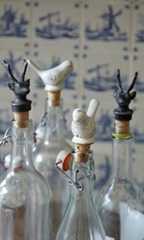 three glass bottles with birds in them sitting on a table