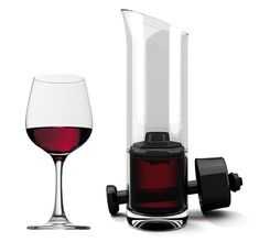 a glass of red wine next to a decanter