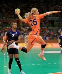 a woman in an orange uniform is jumping up to catch a ball with her right hand