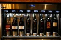 several bottles of wine are on display in a stainless steel case