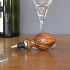 a wine glass and corkscrew on a table next to a bottle of wine