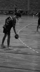 a group of people standing on top of a basketball court holding ball and gloved hands