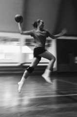 a woman is jumping in the air with a ball