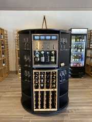 a wine cooler with several bottles and glasses on it in the middle of a room
