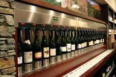 bottles of wine are lined up on the shelf in front of each other at a restaurant