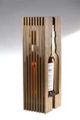 an empty bottle in a wooden box on a white surface with light coming from it