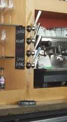 an espresso machine sitting on top of a counter next to some wine glasses