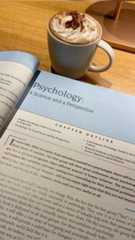 a cup of coffee sitting on top of an open book