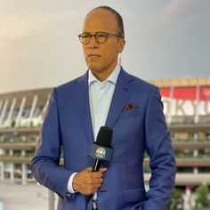 a man in a blue suit holding a microphone