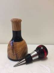 a wine bottle with a wooden stopper sitting next to it's cork holder