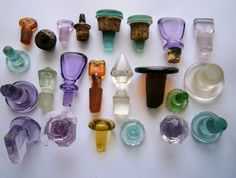 many different colored glass objects on a white surface
