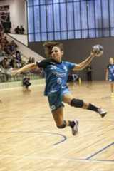 a person jumping up in the air to catch a frisbee on a court