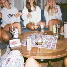 four women sitting around a table with wine glasses
