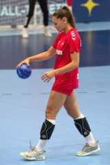 a woman in red uniform holding a blue ball