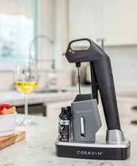 a blender sitting on top of a counter next to a glass of wine