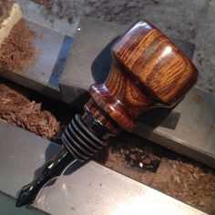a close up of a wooden object on a metal work bench with wood shavings