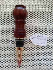 a wooden wine stopper sitting on top of a table next to a price tag