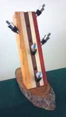 a wooden sculpture with four toothbrushes on it's sides and three holes in the middle