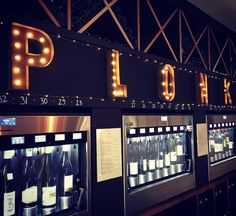 a row of vending machines with lighted letters on the front and back of them