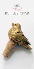a gold bird sitting on top of a cork bottle stopper with the words bird international bottle stopper above it