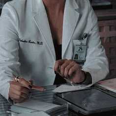 a woman in a lab coat sitting at a table