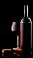 a bottle of wine next to a glass filled with red wine