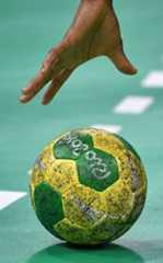 a hand reaching for a soccer ball on the ground