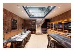 the dining room is set up with long tables and chairs, along with a skylight